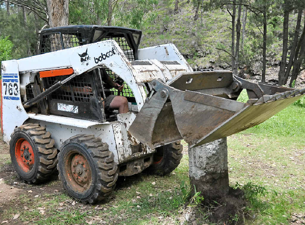 Tony Pearson places a boulder with his Bobcat during the working bee at Cambanoora Gorge.